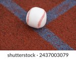 Small photo of one baseball on infield of sport field