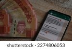 Small photo of Financial and investment concepts, online loan (jerat pinjol, gali lubang tutup lubang). Man with shovel, pitchfork, Indonesian Rupiah. Jakarta - March 14 2023.