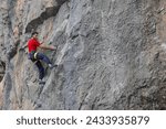 Small photo of Man in red t-shirt scalded on gray wall, playing sports, reaching limit