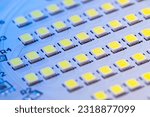 Small photo of Close-up view of an electronic board with a bunch of LED modules. The board is lit with a blue light. A set of Light Emitting Diodes assembled on a board.