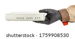 Small photo of Man hand in black protective glove and brown uniform holding VoIP gateway isolated on white background