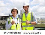 Small photo of Portrait colleage male and femal engineer with yellow safety vest and white hard hat work on roof top of building , Close up system engineer with Thump up express good job or job done .