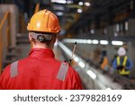 Portrait back view of technician with red safety uniform and orange hard hat Industrial and technology