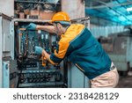 Small photo of Electrical technician tests wiring, polarity, grounding, voltages and performs electrical maintenance using hand tools that involve clamp meter, screwdriver, and cutter. The foreman's routine tasks.