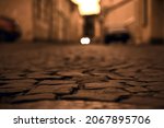 Old town in Europe at sunset with retro vintage cobble stone. cobble paving Stones background for walking. Small evening street with car parking in Saint Petersburg. narrowest street  - Repin street