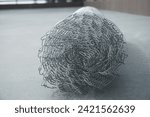 Small photo of Coil of steel wire. Rabitz mesh netting roll as background. Construction iron wire or mesh in a roll. Mesh wire rolls of iron stainless steel, galvanized metal sheets. wire mesh rolls farm fence