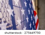 Illegal immigration concept  Background of transparent American flag behind a chain link fence and concrete stairway 