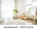 Kindergarten room with easel chair and table for painting. children's room and furniture and natural green flowers on white windowsill