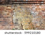 Close-up view of cracked old building brick wall with eroded bricks on top, background concept