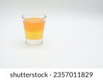 Small photo of A Shot glass with Orange Jelly and Lemon Jelly isolated on a white background