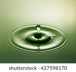 Small photo of Green Plop - Water drop photography, one or two drops of water dropped from height into a tray filled with water and captured as they hit the water or collide with each other.