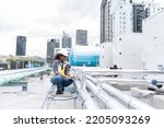 Small photo of Female engineer work using laptop computer for checks or maintenance in sewer pipes area at construction site. African American woman engineer working in sewer pipes area at rooftop of building