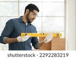 Small photo of Professional male carpenter using water level meter or spirit level tool in wood workshop. Asian male joiner working in furniture workshop. SME, Start up and small business concept