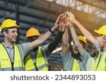 Small photo of Group of diverse warehouse workers join hands together in storage warehouse. Team of male and female warehouse workers at work. Completed finish job. Successful of work concept