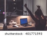 Success, victory or meeting deadline concept. Young,excited caucasian woman or teenager is holding her hands up in the air. Female teenager working late at night in her room. Success concept.