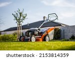 Small photo of Lawn mover on green grass in modern garden. Machine for cutting lawns.