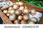 Small photo of Close up of fresh onions being sold on a vegetable seller's table in a traditional market, one of the healthiest spices.