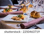 Small photo of Place setting, cutlery and plate, glasses and napkins table setting ideas. Appetizer first course for meal menu. Fish and meat with salad. Party and wedding food ideas. Orthodox Jewish wedding challah