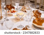 Small photo of Wedding, bar mitzvah Orthodox Jewish wedding event challah-bread with knife as per Hasidic tradition. Set on dining place setting. Shabbat meal