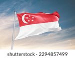 Waving flag of Singapore in beautiful sky. Singapore flag for independence day. The symbol of the state on wavy fabric.