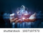 Hands shows the atom on a dark blurred background.