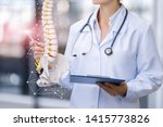 A medical worker shows the spine on blurred background.