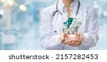 Small photo of The concept of providing pharmacy services. Pharmacist shows a basket of medicines on a blurred background.