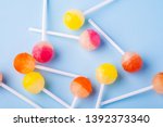 Scattered lollipop candies on blue background top view