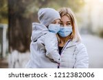 a girl with a child stands on the road in a protective medical mask. Dense smog on the streets. Epidemic of the flu