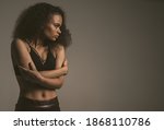 Small photo of Timidity, panic attack, self-preservation, fear African American girl standing covered with hands in black bare shoulder top isolated on grey background. Human emotions, facial expression concept.