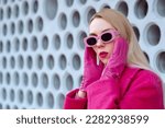 Fashionable confident woman wearing trendy pink sunglasses, leather gloves, fuchsia color coat. Close up fashion portrait. Copy, empty space for text