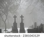 Melancholic mood in a foggy old Christian cemetery. Winter day. 