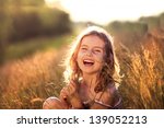 Adorable little girl laughing in a meadow - happy girl