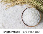 Wooden bowl with rice on rice and rice ears background with copy space for your text, top view. Natural food high in protein