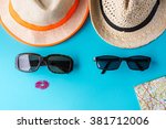Tourism concept. He and she, a couple are ready for the road. Two hats, sunglasses and travel map against a blue background.