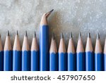 Small photo of Standing out of the crowd. Being different concept. A row of perfect pencils with one broken. A symbol of disfigurement.