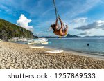 A woman on a swing at the 7 Commandos island beach, El nido, Palawan, Philippines