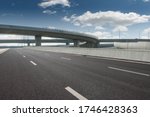 Clear blue sky and white clouds in the background, highway overpass curved approach bridge 