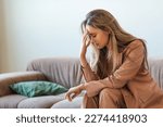 Small photo of Mentally burnt out and completely devastated, the young woman sits on the couch with her head in her hands. The businesswoman has lost her motivation to work and live. Close-up photo.