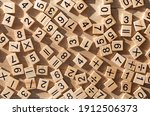 Scattered wooden plaques with numbers and signs. Flat lay. Teaching material in mathematics, Montessori method. School background. Problem solving concept. Laser cutting and printing on wood.