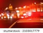 Small photo of Police car red color emergency light (siren) at the night city lights background.