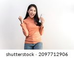 Portrait photo of young beautiful Asian woman feeling happy or surprise shock and holding smart phone on white background can use for advertising or product presenting concept.