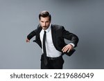 Small photo of Man business happy in jacket and shirt jumping and running on gray background raised hands up serious face. Successful business