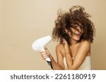 Woman dries curly afro hair...