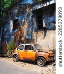 Small photo of An old car wreck with an old red brick wall in an old ally of Talad Noi (Charoen Krung) in Bangkok, Thailand, one of the oldest neighborhoods in Bangkok, Street art is filled with historic temples and