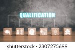 Small photo of Qualification concept, Wooden block on desk with qualification icon on virtual screen.