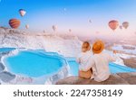 Concept Travel tourist background Pamukkale Turkey. Lover couple watching Hot air balloon flying Travertine pool and terraces.