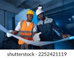 Two Professionals african american engineer holding blueprint and discussing work plan background industry CNC machinery.
