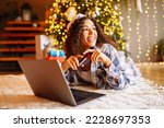 Young woman with credit card, gifts, and laptop. Online shopping at Christmas holidays. 