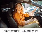 Smiling woman driving a car. Young traveler driving. Car travel, lifestyle concept.